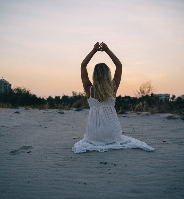 Silhouette of a person meditating against a calm sunset.